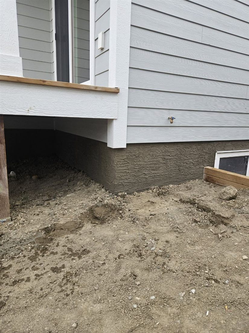 New-construction foundation freshly finished with grey parging
